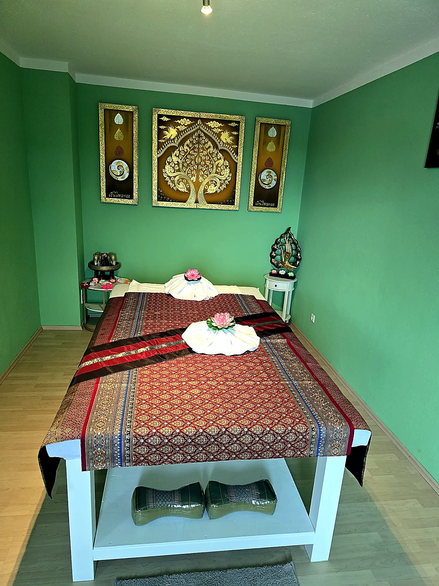 Massageraum von UDOM MASSAGE mit traditionell dekorierter Thai-Liege